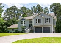 Charming two-story home with gray siding, stone accents, attached two-car garage and well-manicured lawn at 76 Vaughn Ne Rd, Cartersville, GA 30121