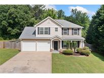 Charming two-story home with a well-manicured lawn and a two-car garage at 174 Randall Dr, Rockmart, GA 30153