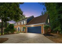 Charming two-story brick home with a dark blue front door and matching garage door at 3228 Turtle Lake Se Dr, Marietta, GA 30067