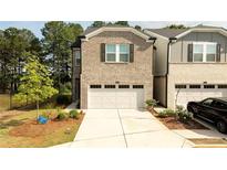 Charming two-story home with a two-car garage and well-manicured front yard at 1825 Villageside Ct, Lawrenceville, GA 30043