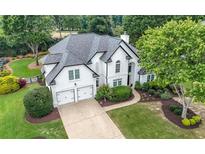 Charming two-story home featuring a well-manicured lawn, mature trees, and a two-car garage at 3065 Foxhall Overlook, Roswell, GA 30075