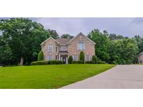 Charming two-story brick home with a well-manicured lawn and mature trees at 157 Hambrick Dr, Stockbridge, GA 30281