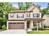 Charming two-story home with a brick and beige facade, featuring a well-manicured lawn and a two-car garage at 2630 Timler Trce, Snellville, GA 30078