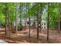 Charming home nestled among mature trees on a well-manicured, sloped lot at 12995 Bucksport Dr, Roswell, GA 30075