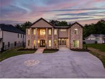 Stunning two-story brick home featuring a spacious driveway and well-manicured lawn at 157 Shadburn Ferry Rd, Buford, GA 30518