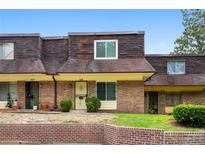 Charming townhouse with brick facade, yellow trim, and well-kept front lawn at 169 Peyton Sw Pl, Atlanta, GA 30311