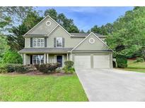 Charming two-story home featuring a well-maintained lawn, a two-car garage, and manicured landscaping at 5229 Pine Branch Ct, Sugar Hill, GA 30518