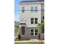 Charming three-story townhome features brick accents, large windows, and a welcoming entrance with a small awning at 2569 Astaire Ct, Atlanta, GA 30318