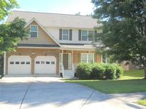 Charming two-story home featuring a stone facade, two-car garage, and well-maintained front lawn at 4750 Crinklepoint Ct, Douglasville, GA 30134