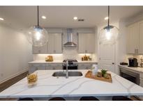 Bright kitchen features pendant lights, stainless steel appliances, and a large island with seating at 1005 Crown Oak St # 44, Johns Creek, GA 30022