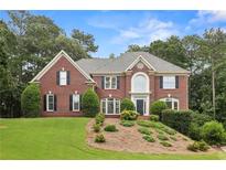Charming two-story brick home boasts manicured landscaping and lush trees at 340 Old York Rd, Johns Creek, GA 30097