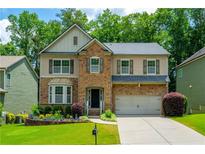 Charming two-story home featuring a brick facade, well-manicured lawn, and attached two-car garage at 4540 Fourth Rail Ln, Cumming, GA 30040