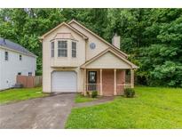 Charming two-story home with a bay window, covered porch, attached garage and lush lawn at 847 Ashley Ln, Stone Mountain, GA 30087