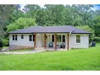 Charming one-story home featuring a painted brick facade and a covered porch with wooden pillars at 1740 Dodson Sw Dr, Atlanta, GA 30311