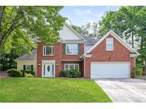 Charming two-story brick home with a well-manicured lawn and attached two-car garage at 1305 Kelly Nelson Dr, Lawrenceville, GA 30043