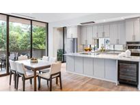 Bright, open kitchen with a marble island, stainless steel appliances, and adjacent dining area with outdoor views at 2575 Peachtree Ne Rd # 6G, Atlanta, GA 30305