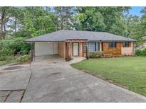 Charming single-story home with brick and wood siding, a covered carport, and a inviting pergola entryway at 2468 Dresden Ne Dr, Atlanta, GA 30341
