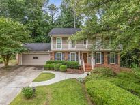 Charming home featuring a brick facade, lush landscaping, and a welcoming front porch at 3541 Castlehill Ct, Tucker, GA 30084