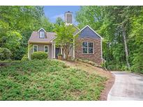 Charming home featuring a stone facade and inviting curb appeal, nestled within lush greenery at 1940 Country Pl, Cumming, GA 30040