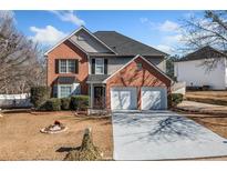 Charming two-story brick home with a two-car garage and well-manicured landscaping at 2885 Field Spring Dr, Lithonia, GA 30058