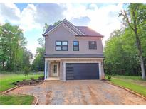 Charming two-story home with brick accents, a modern garage door, and lush green surroundings at 41 Birch Ct, Mcdonough, GA 30253