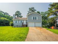 Charming split-level home featuring a two-car garage, stone accents, and a well-maintained lawn at 4331 Wrexham Ct, Snellville, GA 30039