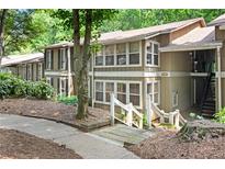 Exterior view of a two-story home with brown siding, white trim, and mature trees, near walkways and stairs at 5145 Roswell Road # 3, Atlanta, GA 30342