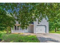 Charming two-story home with a garage, inviting porch, and well-maintained front yard at 7384 Birch Hollow Pl, Douglasville, GA 30134