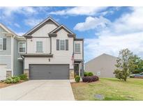 Charming two-story home with a gray garage door and a well-manicured lawn at 739 Woodstock Grove Dr, Woodstock, GA 30188