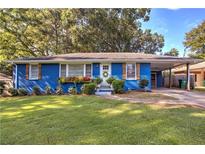 Charming blue brick home with well-maintained lawn, flower boxes, and carport at 854 Parkway Se Dr, Smyrna, GA 30080