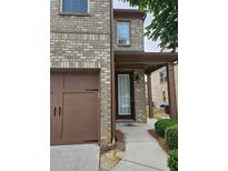 Brick home featuring a garage and covered front entry at 6585 Story Cir, Norcross, GA 30093
