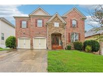 Beautiful two-story brick home featuring a well-manicured lawn, stone accents, and a two-car garage at 1476 Rolling View Way, Dacula, GA 30019