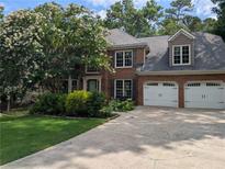 Charming brick home featuring a well-manicured lawn and a two-car garage at 5882 Grandview Nw Ct, Acworth, GA 30101