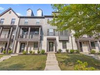 Charming townhome with a mix of white brick and gray siding, a well manicured lawn, and a private balcony at 125 Climbing Ivy Cir, Fayetteville, GA 30214