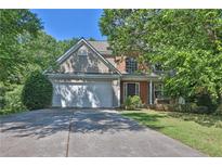 Charming two-story home featuring a two-car garage and a manicured front lawn with lush greenery at 1387 Sw Haynes Meadow Trl, Grayson, GA 30017