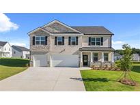 Charming two-story home featuring brick and stone accents, a two-car garage, and a beautifully landscaped front yard at 301 Sandy Oak Dr, Loganville, GA 30052