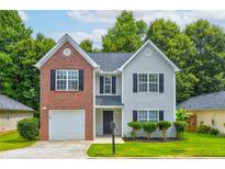 Charming two-story home features a well-manicured lawn, a brick facade, and complementary neutral siding at 7006 Mahonia Place, Stonecrest, GA 30038