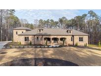Beautiful brick home featuring manicured lawn, arched entryway, and thoughtfully designed landscaping at 1380 Sw Elva Sw Dr, Atlanta, GA 30331