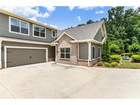 Charming home showcasing a two-car garage, well-manicured landscaping, and a mix of stone and siding accents at 1896 Grove Field Ln # 29, Marietta, GA 30064