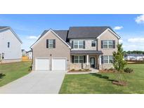 Beautiful two-story home featuring a two-car garage, stone accents, and a well-manicured lawn at 281 Sandy Oak Dr, Loganville, GA 30052