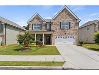 Charming two-story brick home with a well-manicured lawn and attached two-car garage at 7207 Gladstone Cir, Stonecrest, GA 30038