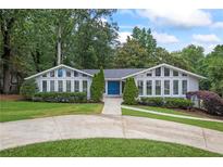 Charming home with a well-manicured lawn, lovely landscaping, and a welcoming blue double-door entry at 3009 Gant Quarters Dr, Marietta, GA 30068