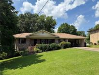 Charming brick home with a well-manicured lawn and an attached carport at 1046 Waterside Se Dr, Conyers, GA 30013