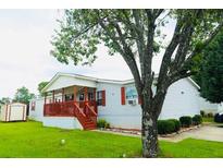 Charming manufactured home boasts a welcoming red porch and well-maintained landscaping at 263 Gulfport Ct, Hampton, GA 30228
