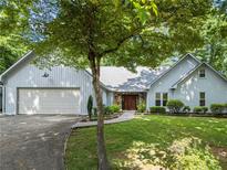 Charming home exterior featuring a well-manicured lawn, stone accents, and a double garage at 4212 Burns Heritage Ne Trl, Roswell, GA 30075