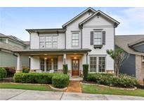 Charming two-story home with a covered front porch, landscaped yard, and a combination of siding and stone accents at 2013 White Cypress Ct, Smyrna, GA 30082