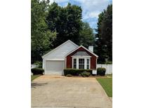 Charming home featuring a brick accent wall, manicured landscaping, and a one-car garage at 214 Chelsea Ct, Woodstock, GA 30189