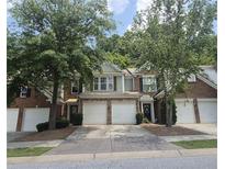 Charming townhome exterior with brick and siding, complemented by a two-car garage and a well-manicured lawn at 2061 Fosco Dr, Duluth, GA 30097
