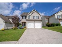 Inviting two-story home with a two-car garage, blue accents and a well-manicured lawn at 4135 Arch Pass, Cumming, GA 30040