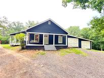 Charming home features a covered porch with a swing and a detached garage with crossbuck doors at 776 Green Dr, Canton, GA 30114